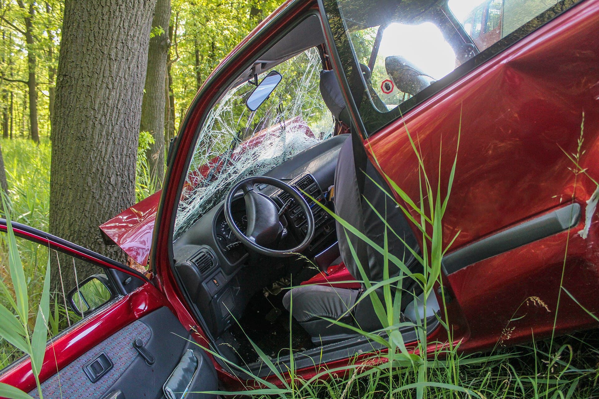 A red car off the road after a collision