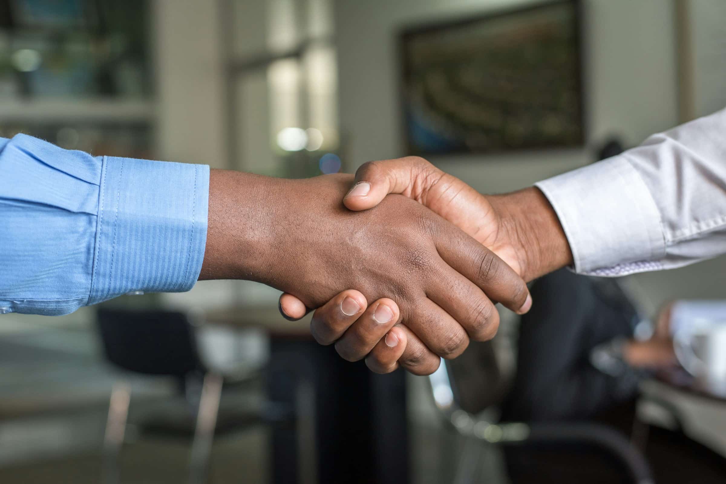 A handshake across an office table at the start of a working relationship